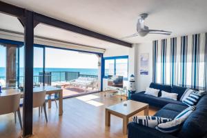 een woonkamer met een blauwe bank en een tafel bij ¡Impactante apartamento a cero linea de mar! in Tarragona