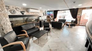 a waiting room with black chairs and a bar at Red Sea Hotel in Eilat