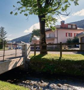 un albero accanto a una recinzione accanto a un edificio di Appartement chaleureux et confortable avec sauna.. a Le Chenit