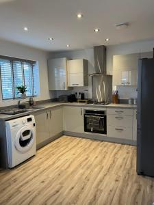 a kitchen with a washing machine and a washer at Hawk House - Furnished Accommodation in Hatfield