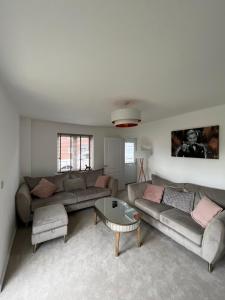a living room with two couches and a coffee table at Hawk House - Furnished Accommodation in Hatfield