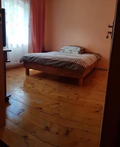 a bedroom with a bed and a wooden floor at Карпатський будинок in Izki