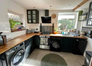 a kitchen with a washer and dryer in it at Luxury Oriental Home with Exotic Garden & Free Parking in West Derby
