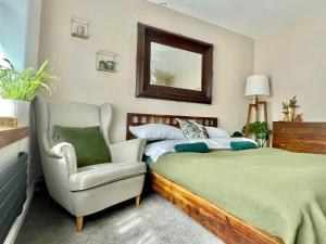 a bedroom with a bed and a chair and a mirror at Luxury Oriental Home with Exotic Garden & Free Parking in West Derby