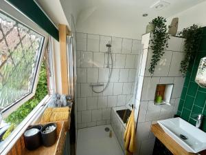 La salle de bains est pourvue d'une douche et d'un lavabo. dans l'établissement Luxury Oriental Home with Exotic Garden & Free Parking, à West Derby