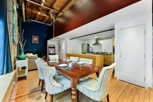 a dining room with a wooden table and white chairs at Stylish 1-bedroom loft in Gas Town in Vancouver