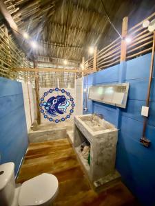a blue bathroom with a toilet and a sink at Playa Jaguar - Beach Club in Moñitos
