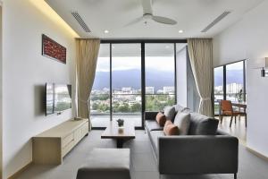 a living room with a couch and a large window at Eastin Tan Hotel Chiang Mai in Chiang Mai