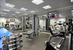 Un gimnasio con equipo cardiovascular y un televisor de pantalla plana. en Mercure London Paddington Hotel, en Londres