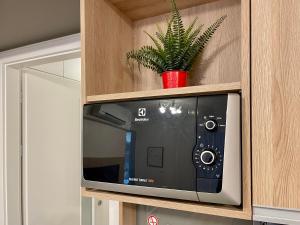 a microwave in a cabinet with a plant in it at Great in Nivy