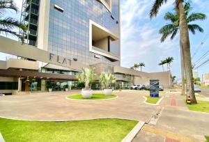 a large building with palm trees in front of it at Loft Executivo-Afonso Pena in Campo Grande