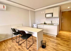 a kitchen with a table and chairs in a room at Loft Executivo-Afonso Pena in Campo Grande