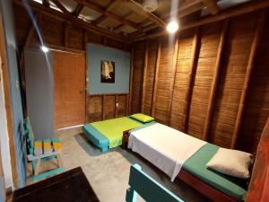 1 Schlafzimmer mit 2 Betten in einem Zimmer mit Holzwänden in der Unterkunft Casa MITA Taganga in Taganga