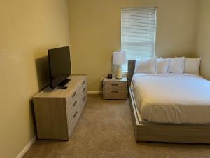 a bedroom with a bed and a flat screen tv at WASHBURN HOTEL SUITES in Topeka