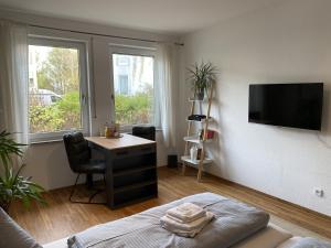 um quarto com uma cama, uma secretária e uma televisão em RR - Tiny Apartment - Parking - Kitchen - Netflix em Magdeburg