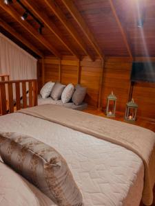 a bedroom with two beds in a room with wooden walls at Pousada e Restaurante Casa Cida e Evandro in Gaspar
