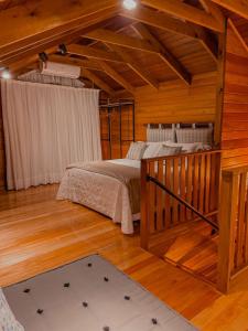 1 dormitorio con 2 camas en una casa de madera en Pousada e Restaurante Casa Cida e Evandro, en Gaspar