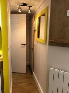 un couloir avec une porte blanche et un miroir dans l'établissement Cosy Studio of 17 square meters at Place Monge 75005, à Paris