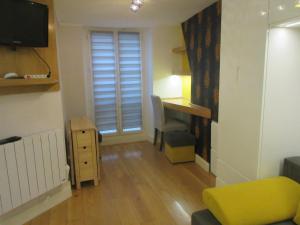 uma pequena sala de estar com uma secretária e uma cadeira em Cosy Studio of 17 square meters at Place Monge 75005 em Paris