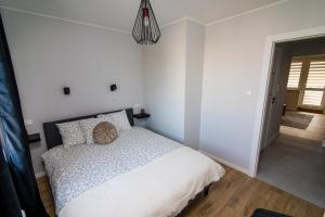 a bedroom with a bed and a pendant light at Apartament KOPERNIK w centrum in Iława