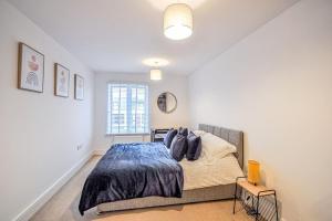 a bedroom with a bed with a blue comforter at Entire Apartment Sleeps 4 Near The River Thames - #1515 in Maidenhead