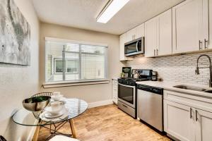 a kitchen with white cabinets and a glass table at Love for Dallas: Close to Deep Ellum & AAC! in Dallas