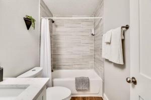 a white bathroom with a shower and a toilet at Love for Dallas: Close to Deep Ellum & AAC! in Dallas