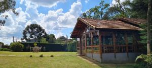 a pavilion in a garden with a table at Arado 313 Suites in Monte Verde