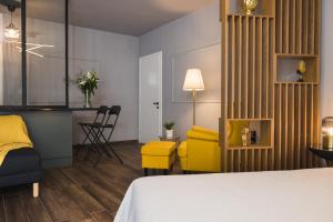 une chambre d'hôtel avec un lit et une chaise jaune dans l'établissement K-Houses A4, à Árta