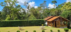 a gazebo in the middle of a lawn with chairs at Arado 313 Suites in Monte Verde