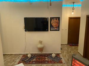 a living room with a flat screen tv on a wall at Nabati hostel in Wadi Musa