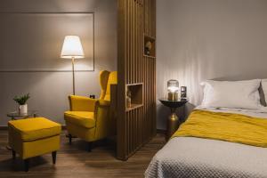 a bedroom with a bed and a yellow chair at K-Houses A4 in Arta