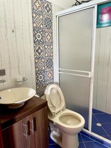 a bathroom with a toilet and a sink at Hacienda El Encanto in Los Santos