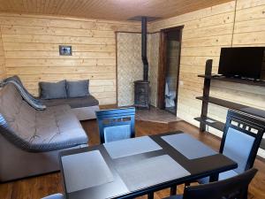 ein Wohnzimmer mit einem Sofa, einem Tisch und einem Kamin in der Unterkunft Kozichky Guest House in Tatariw