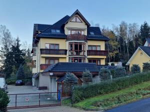 a large yellow house with a black roof at Skalna View Apartament z widokiem dwie sypialnie i salon balkon parking in Karpacz