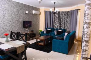 een woonkamer met blauwe stoelen en een tafel bij PK Ocean A3 in Mombasa