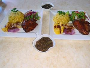 tres platos con diferentes tipos de comida en una mesa en Matthew's Miracle View en Roseau