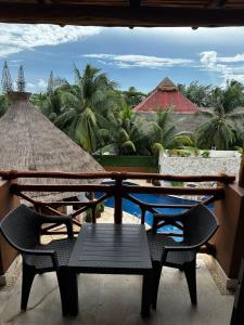 een tafel en stoelen op een balkon met uitzicht bij Hotel Beló Isla Mujeres - All Inclusive in Isla Mujeres
