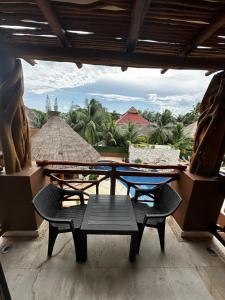 een tafel en stoelen op een balkon met uitzicht bij Hotel Beló Isla Mujeres - All Inclusive in Isla Mujeres