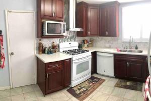 a kitchen with wooden cabinets and a white stove top oven at 2 bedroom house or Private Studio in quiet neighborhood near SF, SFSU and SFO in Daly City