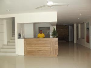 un hombre parado detrás de un mostrador en una casa en L Bajo Hotel, en Labuan Bajo