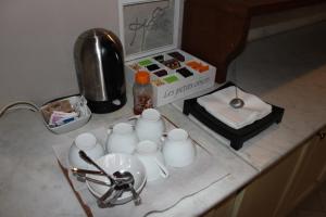 a counter top with a coffee maker and cups on it at Florence Decamerone B&B in Florence