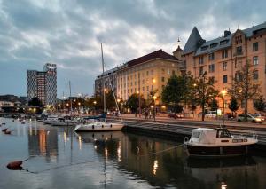 un grupo de barcos atracados en un río con edificios en Fabulous Central Apartment Helsinki, en Helsinki