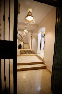 an empty hallway with stairs and a chandelier at Atlantica Ifri Surf Suites in Tamraght Oufella