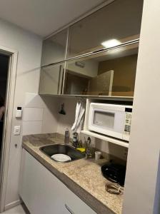 a kitchen with a sink and a microwave at Flat Setor de Hotéis Norte no Hotel Fusion in Brasilia