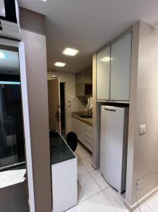 a kitchen with white cabinets and a refrigerator at Flat Setor de Hotéis Norte no Hotel Fusion in Brasilia