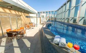 a swimming pool with tables and chairs next to a building at Flat Setor de Hotéis Norte no Hotel Fusion in Brasília