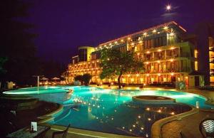 a large swimming pool in front of a building at night at Hotel Koral - Free Parking in Saints Constantine and Helena