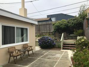 a patio with chairs and a table in a backyard at 2 bedroom house or Private Studio in quiet neighborhood near SF, SFSU and SFO in Daly City