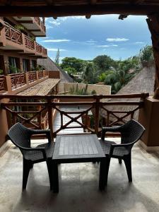 een tafel en stoelen op een balkon met uitzicht bij Hotel Beló Isla Mujeres - All Inclusive in Isla Mujeres